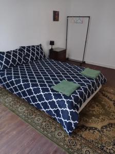 een slaapkamer met een blauw en wit bed met groene kussens bij antoinette in Carcassonne
