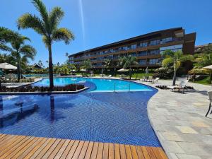 a swimming pool with a resort building in the background at Eco Resort Praia dos Carneiros - Flats & Bangalô - LocarHouse in Tamandaré