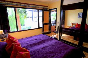 ティアスにあるApp-Tropican 8Aのベッドルーム(紫色のベッド1台、大きな窓付)