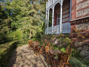 une rangée de tables et de chaises en bois sur une maison dans l'établissement Villa Eliane - parking privé, à Étretat