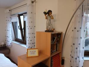Eine Statue eines Mädchens auf einer Kommode im Schlafzimmer. in der Unterkunft Ferienwohnung Kiruga in Kippenheim