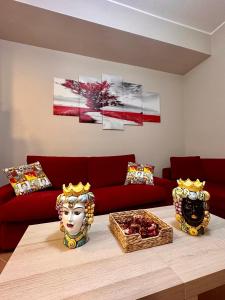 a living room with a red couch and a table at Tutti i Comfort Giuliano's Apartment in Messina