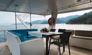 uma mesa e cadeiras num barco sobre a água em Vira Yacht em Göcek