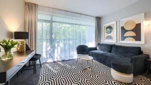 ein Wohnzimmer mit einem blauen Sofa und einem Tisch und Stühlen in der Unterkunft Solny Resort, Sun & Snow in Kołobrzeg