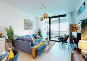 een woonkamer met een blauwe bank en stoelen bij 2 BDR Apartment in ADDRESS BEACH RESORT in Dubai