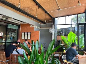 a group of people sitting at tables in a restaurant at Phuket Siam Villas - SHA PLUS in Chalong