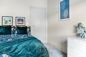 a bedroom with a bed with a green comforter at Brand New 1-Bed Flat Steps from Clifton NTU Campus in Nottingham