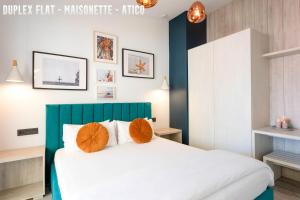 a bedroom with a large white bed with orange pillows at UNIQ flats in Alicante