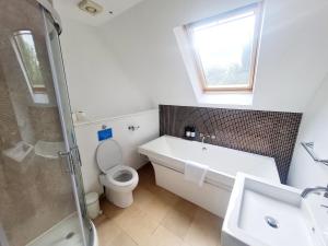 een badkamer met een bad, een toilet en een wastafel bij The Head Gardeners Cottage, Dunbar in Dunbar