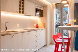 cocina con fregadero y mesa con taburete rojo en UNIQ flats, en Alicante