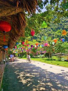 een groep mensen die fietsen in een straat met papieren lantaarns bij Quoc Khanh Bamboo Homestay in Ninh Binh