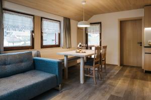 Haus Margreth في ميلاو: غرفة معيشة مع طاولة طعام وأريكة