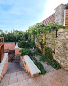 a garden with a bench next to a stone wall at Attic apartment with a terrace in Sežana