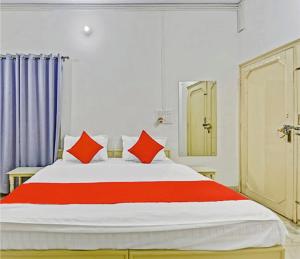 - une chambre avec un grand lit et des oreillers rouges dans l'établissement Abode Homestay, à Jaipur