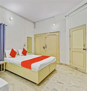 Abode Homestay في جايبور: غرفة نوم عليها سرير ومخدات حمراء