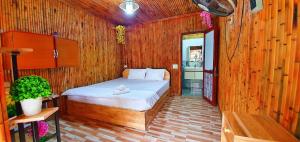 a bedroom with a bed in a wooden room at Quoc Khanh Bamboo Homestay in Ninh Binh