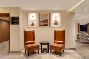 a waiting room with two chairs and a table at Lemon Tree Suites, Whitefield, Bengaluru in Bengaluru