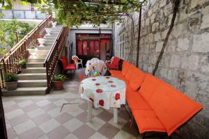 an orange couch with a table on a patio at Apartment Duje & Josipa in Trogir
