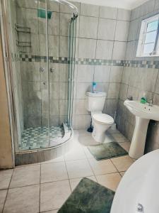 y baño con ducha, aseo y lavamanos. en Sea Breeze Manor - Green Unit, en East London