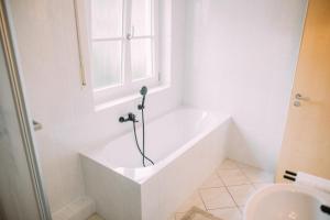 uma banheira branca na casa de banho com uma janela em Luxury Suite - Therme ED - Messe MUC - Parken - WLAN em Erding