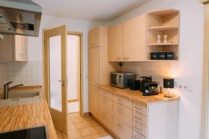 eine Küche mit Holzschränken und einer Mikrowelle in der Unterkunft Luxury Suite - Therme ED - Messe MUC - Parken - WLAN in Erding