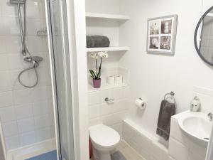 a white bathroom with a toilet and a sink at Travaal.©om - 2 Bed Serviced Apartment Farnborough in Farnborough