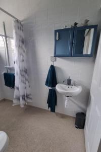 a bathroom with a sink and a blue cabinet at Cornish Village Getaway in Gwennap