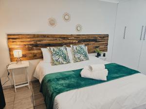 a bedroom with a large bed with a wooden headboard at Sea Breeze Manor - Green Unit in East London
