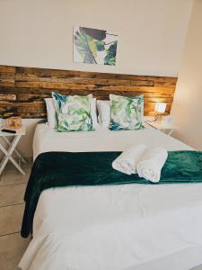 a bedroom with a large white bed with two pillows at Sea Breeze Manor - Green Unit in East London
