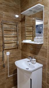 a bathroom with a white sink and a mirror at Гостьовий Будинок Апартаменти в тихому центральному районі Полтави Смарт-квартири in Poltava
