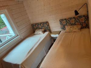 two beds in a small room with a window at Välkommen till vårt vackra hus in Gnesta