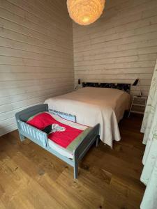 Un dormitorio con una cama con una manta roja. en Välkommen till vårt vackra hus, en Gnesta