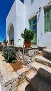 a house with a stone wall and some plants at Spice Suites-Lime in Amorgos