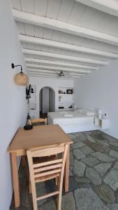 uma mesa e cadeiras num quarto com uma parede branca em Spice Suites-Lime em Amorgós