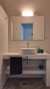 uma casa de banho com um lavatório e um espelho em Spice Suites-Lime em Amorgós