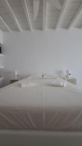 a large white bed in a white room at Spice Suites-Lime in Amorgos