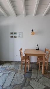a wooden table and two chairs in a room at Spice Suites-Lime in Amorgos