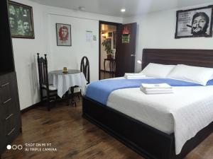 een slaapkamer met een bed en een kleine tafel bij Hotel el Che No apto para corruptos in Azogues