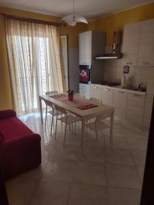 - une cuisine avec une table et des chaises dans la chambre dans l'établissement Casa Vacanze Il Tramonto Spadafora, à Spadafora