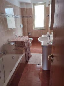 La salle de bains est pourvue d'une baignoire, d'un lavabo et de toilettes. dans l'établissement Casa Vacanze Il Tramonto Spadafora, à Spadafora