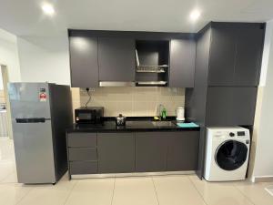 uma cozinha com um frigorífico e uma máquina de lavar roupa em Encorp Marina, 2 Bedroom with bathtub, 6 pax, 5mins to LEGOLAND em Nusajaya