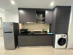 a kitchen with a refrigerator and a washing machine at Encorp Marina, 2 Bedroom with bathtub, 6 pax, 5mins to LEGOLAND in Nusajaya