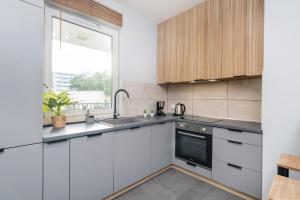 a kitchen with white cabinets and a window at Nakielska Sesame Premium Apartment in Warsaw