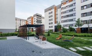 a park with chairs and a pavilion in front of a building at Nakielska Sesame Premium Apartment in Warsaw