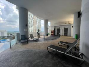 um quarto amplo com cadeiras e uma piscina num edifício em Encorp Marina, 2 Bedroom with bathtub, 6 pax, 5mins to LEGOLAND em Nusajaya