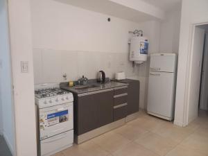 a kitchen with a stove and a sink and a refrigerator at Apart272 in Río Cuarto