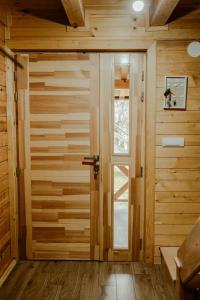 una puerta en una habitación con paredes de madera en Planinska kuca ZALIV, en Zaovine
