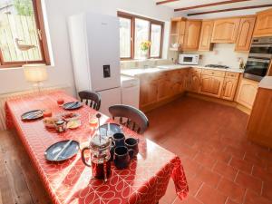 a kitchen with a table with a red table cloth at Fountain Folly in Saint Dogmaels
