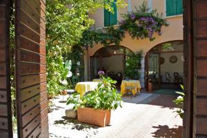 einen Innenhof mit einem Tisch und Stühlen in einem Gebäude in der Unterkunft Hotel San Filis in San Felice del Benaco