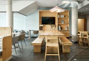 una sala da pranzo con tavolo e sedie in legno di B&B HOTEL Paris Grand Roissy CDG Aéroport a Roissy en France